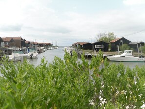 Traditional houses line the river's edge, offering a peaceful retreat with access to boats and scenic views.