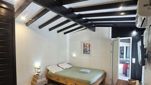 Ein Schlafzimmer mit einem hölzernen Bett, einem Nachttisch mit Lampe, einem Bild an der Wand und einem Holzbüro.