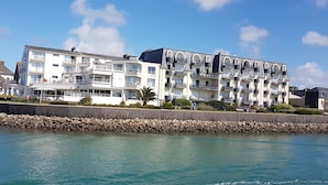 Un hôtel à plusieurs étages doté de balcons, situé au bord de l’eau.