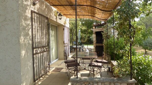 An outdoor patio with stone walls, a table with chairs, and a stone fireplace. - The Cabanon (Saint-Saturnin-Lès-Apt)