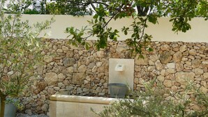 A stone wall with a non-potable sign, a stone bench, and a metal bucket. - The Cabanon (Saint-Saturnin-Lès-Apt)