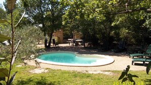 A backyard with a swimming pool, surrounded by trees and outdoor furniture. - The Cabanon (Saint-Saturnin-Lès-Apt)