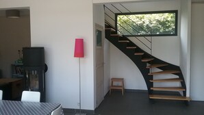 A modern interior with a curved staircase, a dining area, and a large window. - Detached family home in the bay of mont saint michel in Cherrueix (Cherrueix)