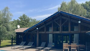 Une cabane en bois avec une piscine, des chaises longues et une table avec des chaises.