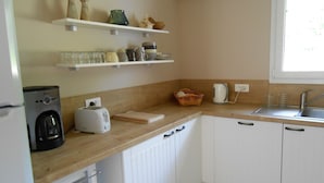 A kitchen with white cabinets, a coffee maker, a toaster, and a sink.