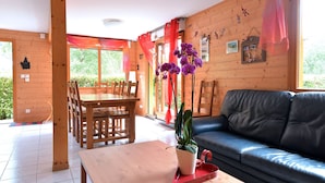 Un interno in legno con un tavolo da pranzo, sedie, un divano e una pianta in vaso.