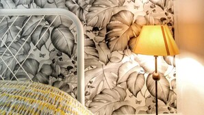 A room with a bed, a nightstand, and a lamp. The wall features a large, detailed leaf pattern. - Drome Provencale house (Saint-Gervais-Sur-Roubion)
