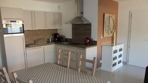 Cocina compacta con comedor, que incluye estufa, pileta y alacenas.