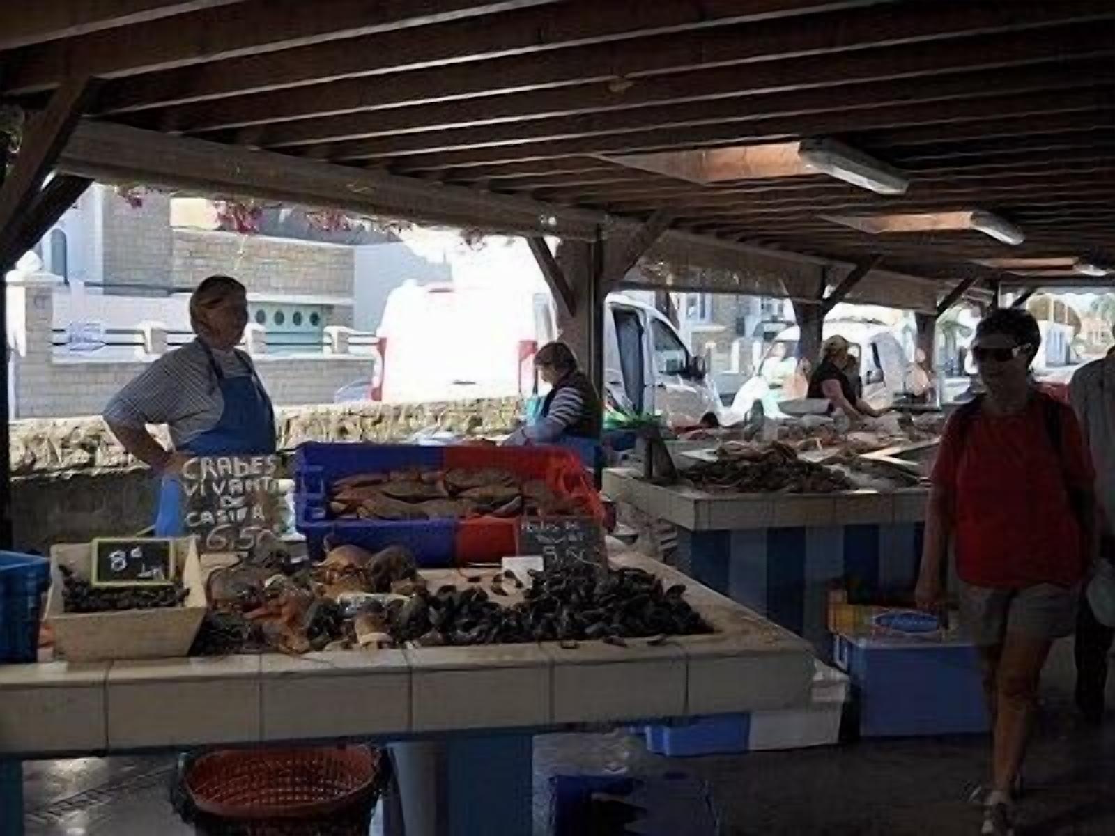 Un quiosc de mercat amb diversos productes de marisc exposats sobre gel.