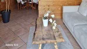 Un espacio habitable compacto con kitchenette, muebles de madera, comedor y sofá.