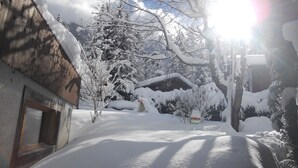 En snötäckt gata med byggnader och träd.