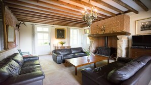 A cozy living room with leather sofas, a wooden coffee table, a fireplace, and a television. - Manoir de 400 sqf near the see, Billard, Babyfoot & Sauna. Pets welcome ! (Sassetot-Le-Mauconduit)