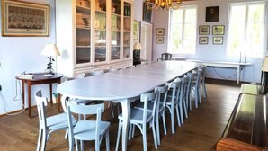 A dining room with a long table and matching chairs, a cabinet with glass doors, and a chandelier. - Manoir de 400 sqf near the see, Billard, Babyfoot & Sauna. Pets welcome ! (Sassetot-Le-Mauconduit)