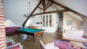 A cozy loft-style room with a pool table, a sofa, a chair, and a bookshelf. - Manoir de 400 sqf near the see, Billard, Babyfoot & Sauna. Pets welcome ! (Sassetot-Le-Mauconduit)