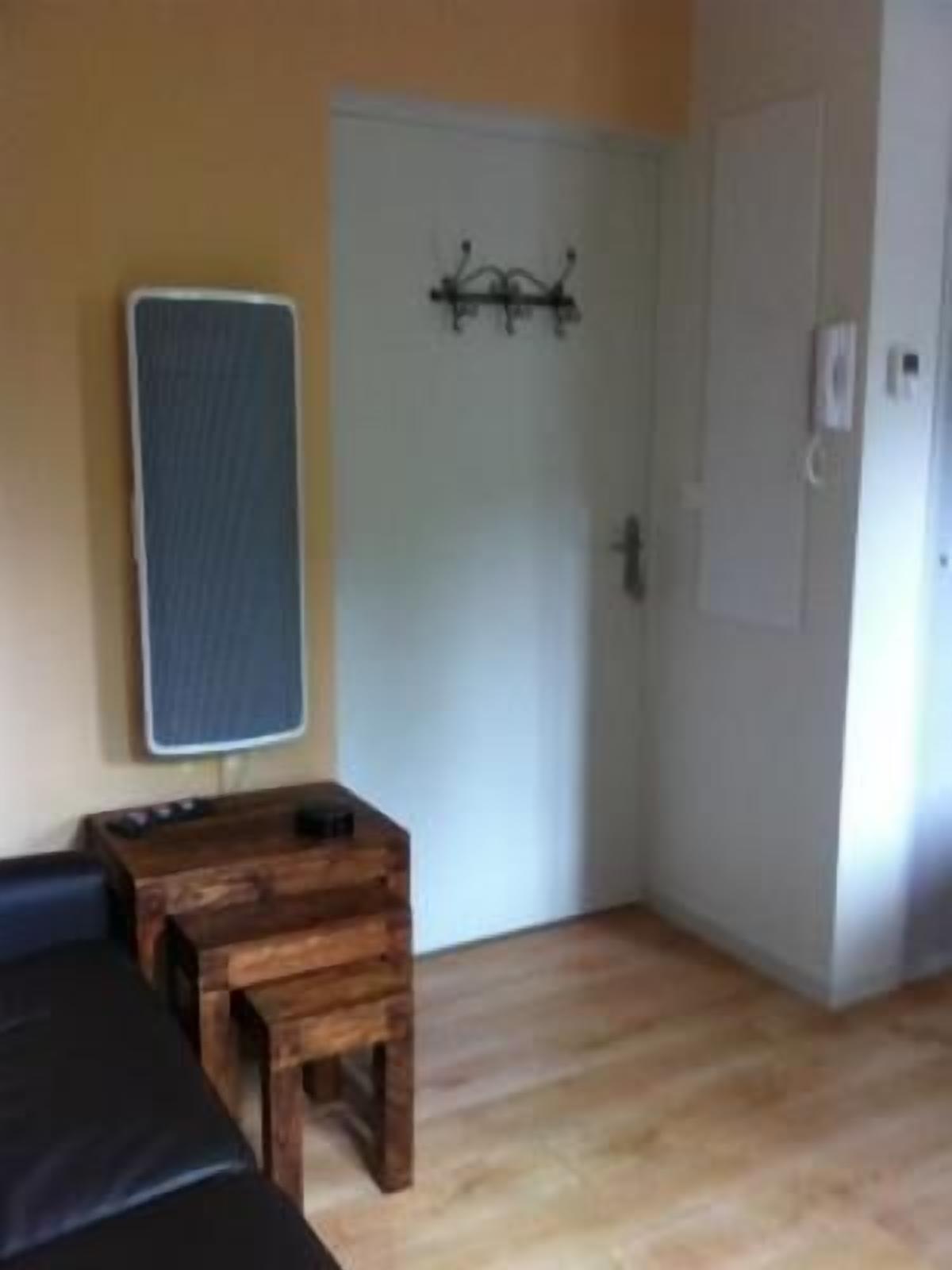 A room with a wooden bench, a small table, and a door with a metal handle.