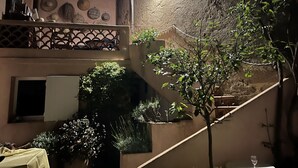 Ein Balkon mit Geländer, einer Treppe und Blumentöpfen.
