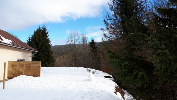 A residential area with a house, a wooden fence, and a snow-covered yard. - TOP-OF-THE-RANGE DUPLEX 95 m2 GARDEN GROUND TO 1.8 KM SKI STATION (Bellefontaine)