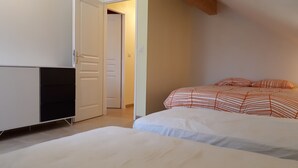 A bedroom with a bed, a wardrobe, and a door leading to another room. - TOP-OF-THE-RANGE DUPLEX 95 m2 GARDEN GROUND TO 1.8 KM SKI STATION (Bellefontaine)