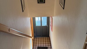 A staircase with a checkered floor leading to a door with windows above. - Cottage in a quiet and green ski trails near hiking (Maisonsgoutte)
