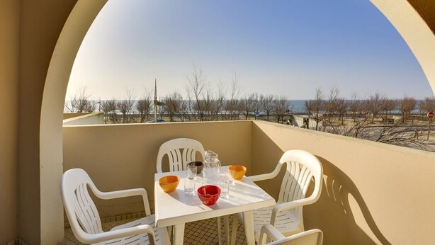A balcony with a table set for two, overlooking a beach. - HOSSEGOR Océan, studio for 3 people (HOSSEGOR)