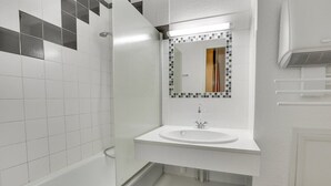 A bathroom with a white sink, a mirror with a mosaic frame, and a shower area. - HOSSEGOR Océan, studio for 3 people (HOSSEGOR)