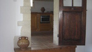 A wooden door with glass panels, a tiled floor, and a kitchen area with a stove and cabinets.