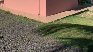 A single-story building with a pink exterior, a small porch, and a satellite dish. - Holiday rental in Petit-Canal (Guadeloupe) (PETIT-CANAL)