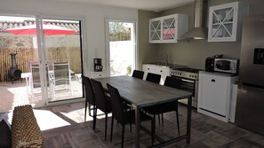 A compact kitchen with a dining area, a stove, a microwave, and a refrigerator. - Au Vieil, house with spa, sauna, bikes 200m from the beach and shops (Noirmoutier-En-L'île)