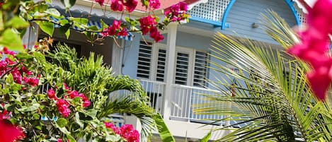 A house with a white exterior, blue trim, and a balcony.