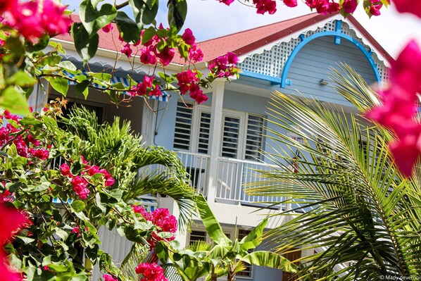 Una casa con fachada blanca, detalles azules y un balcón.