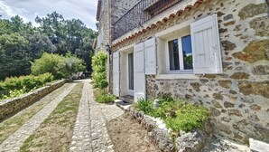 A stone house with a tiled roof, white shutters, and a small balcony. - Cottage, quiet - On the heights of Anduze - 4 people (Anduze)