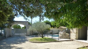 Une propriétéClose, dotée d’une piscine, de murs en pierre et d’un petit arbre.