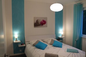 Relax in a stylish room with a large bed, two bedside tables, and a decorative piece above the bed.