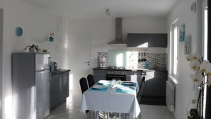 Una cocina moderna con comedor, que incluye refrigerador, estufa y lavaplatos.
