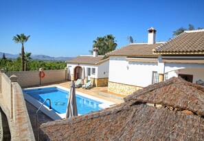 Enjoy a pool area with a clear view of the surrounding landscape, palm trees, and distant mountains.