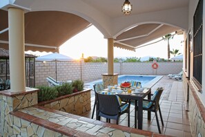 Relax by the pool or lounge on the patio with a round table and chairs.