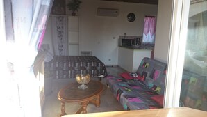 Een kamer met twee bedden, een klein tafeltje met een kom, een magnetron en een spoelbak.