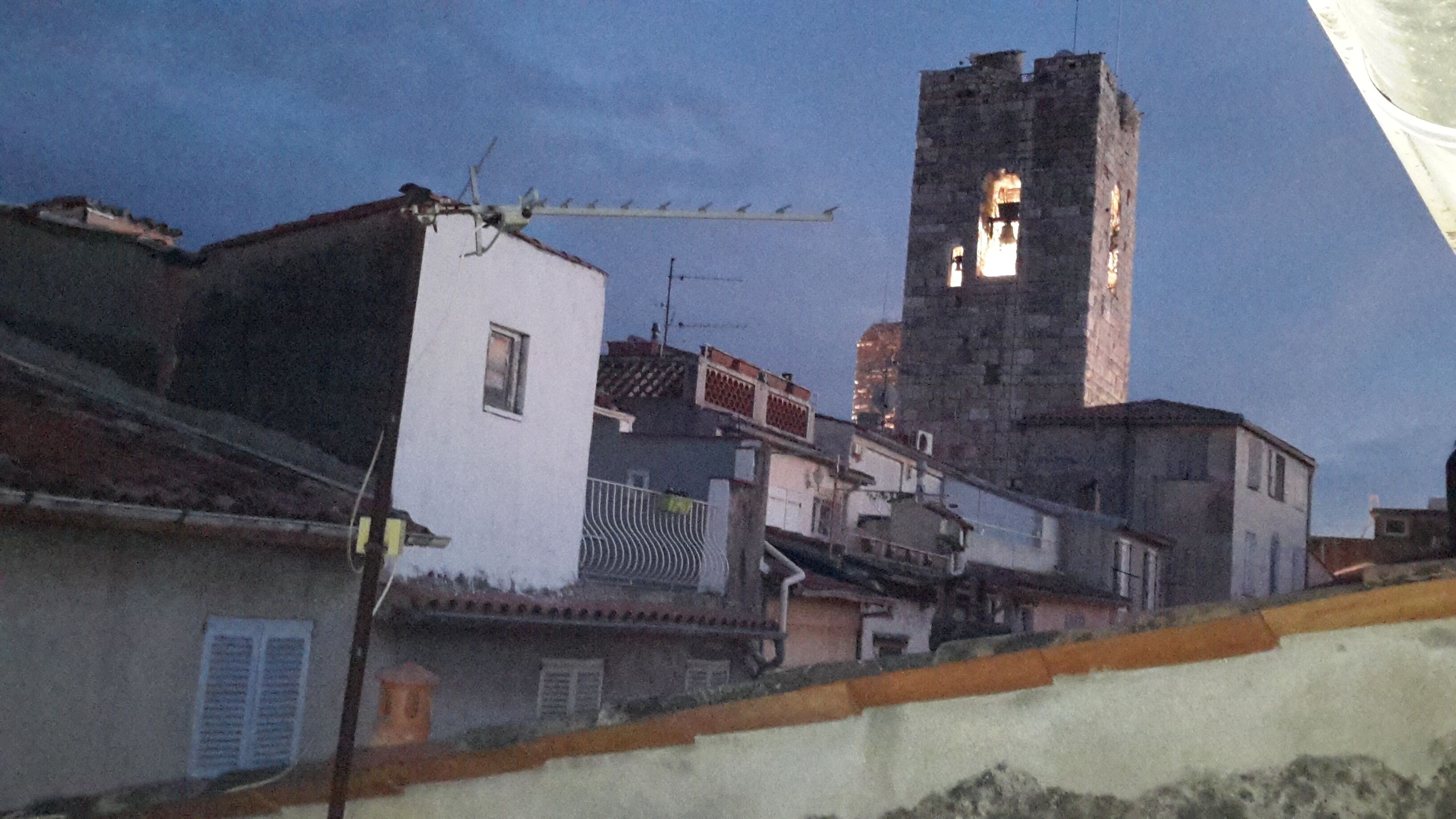 Un edificio histórico con un campanario, rodeado de construcciones residenciales.