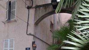 A cobblestone street with a stone archway, a palm tree, and a building with a sign reading "PLACE DE REVEL." - Located in old Antibes, 2 steps from shops, sleeps 2 to 3 (Antibes)