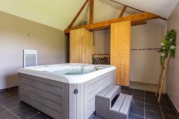 A modern bathroom with a wooden hot tub, a shower area, and a tiled floor.