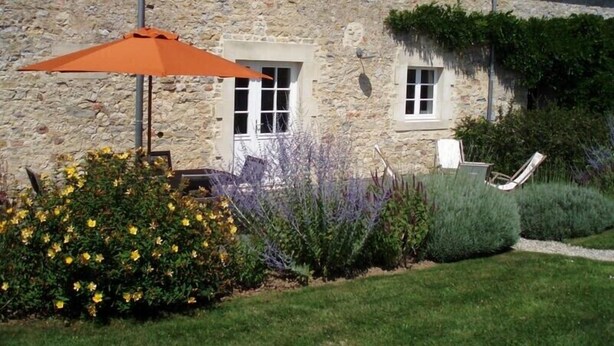 A stone building with a garden, outdoor seating, and a clear sky. - House 20 mn from the beaches, 7 people, neat decoration, fully equipped (Crouay)