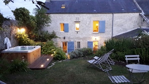 A stone house with a hot tub, outdoor seating, and a well-maintained garden. - 18th century stone house in the heart of the D-Day landing beaches  (Ver-Sur-Mer)
