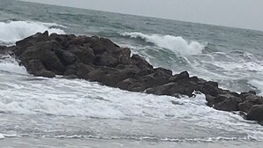 Uma costa rochosa com ondas quebrando nas pedras.
