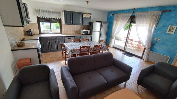 Un espace de vie compact comprenant une kitchenette, un coin repas et un espace détente.