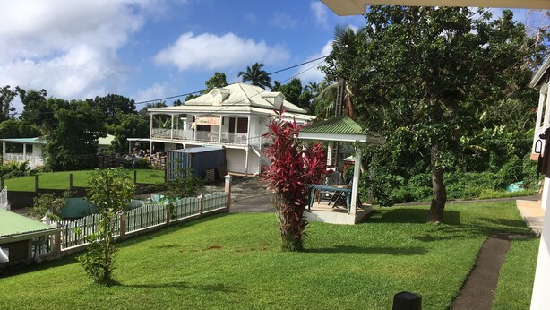 Une maison dotée d’un porche abrité, d’une cour clôturée et d’un petit jardin.