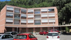 Un edificio de varios pisos con un estacionamiento al frente.