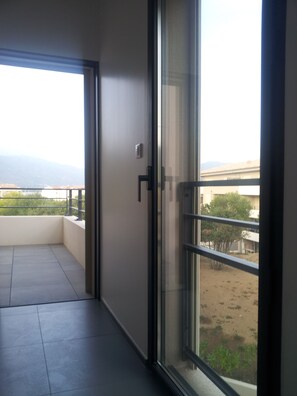 A balcony with a view of a distant landscape and mountains. - On the way to the beaches, a new luxury residence, T3, sleeps 6. (Propriano)