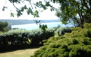 Un paysage naturel comprenant une étendue d’eau, des zones herbeuses et une végétation arbustive dense.
