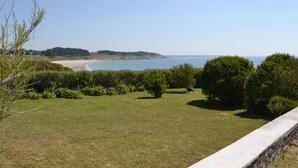 A grassy area with a view of the sea and distant hills. - Exceptional sea and island view. A haven for nature in a protected site (Névez)