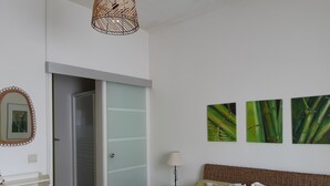 A bedroom with a bed, a nightstand, a lamp, a wardrobe, and wall art. - Near the beach, detached single-storey house, enclosed garden, nearby golf course (Vila Nova de Gaia)